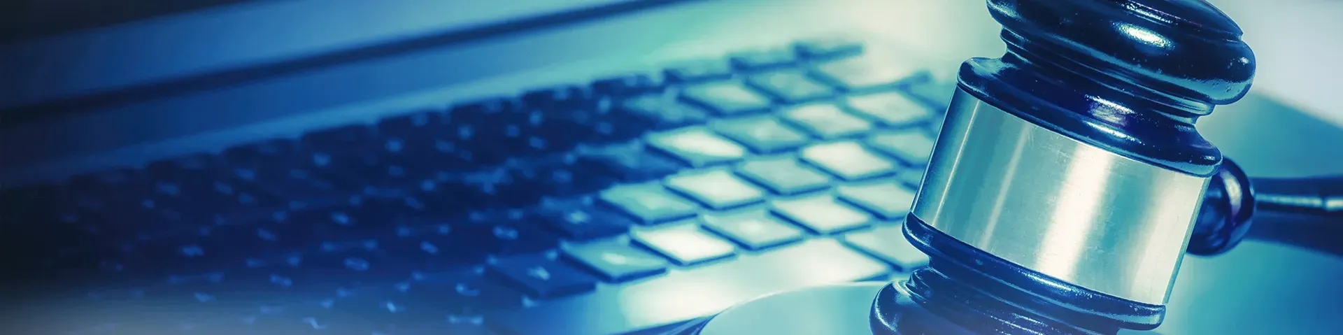 Judge’s gavel resting on a laptop keyboard